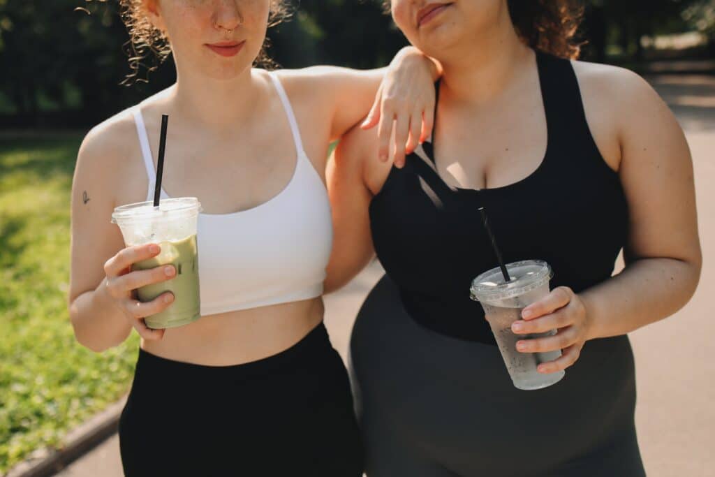 Women in Crop Tops Holding Disposable Cups with Drinking Straw